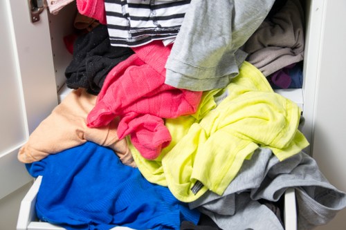 Operatives using lifting aids and protective gear while clearing a property